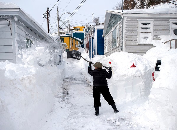 В воскресенье, 19 января 2020 года, житель убирает снег в Сент-Джонсе