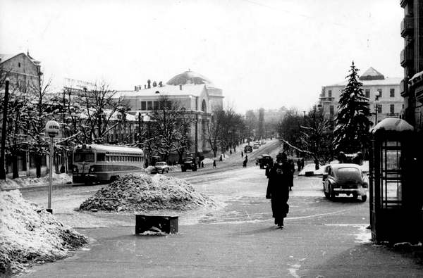 Конец 1950-х годов Владимирская улица в районе Театральной площади. Кучи снега не лежали вдоль проезжей части до весны, пока сами не таяли; их вывозили коммунальные службы. И по улицам зимой можно было ходить без риска сломать ногу (или шею).