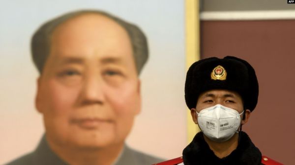 Фото:  Китайский полицейский на площади Тяньаньмэнь в Пекине на фоне портрета Ма