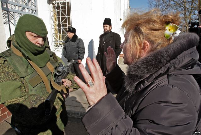 Женщина разговаривает с «зеленіми человечками» возле воинской части в Новоозерном, 3 марта 2014 года