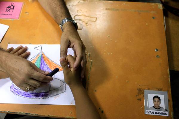 Мальчика с аутизмом учат рисовать. Фото: Franklin Reyes / AP