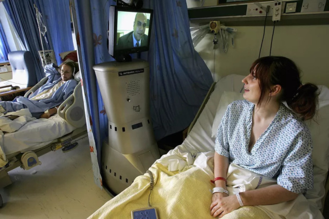 Пациентка лондонской больницы общается с лечащим врачом через видеоэкран робота удалённого присутствия Фото Getty