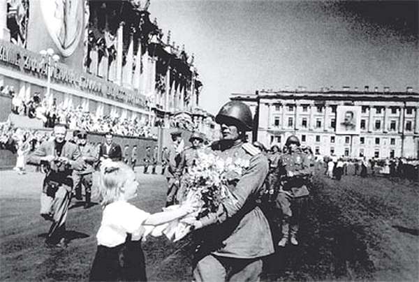 Солдаты идут по мирному Ленинграду. Цветы — победителям. Фото из архива Александра Цыганова.