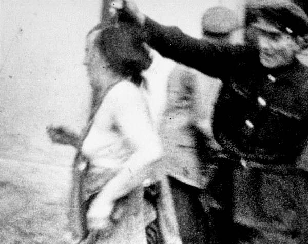 Другое фото изображает милиционера в униформе с повязкой на левой руке, который участвует в аресте евреев на львовской улице. [