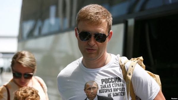 Один из отъезжавших позировал фотографам в майке с изображением российского през