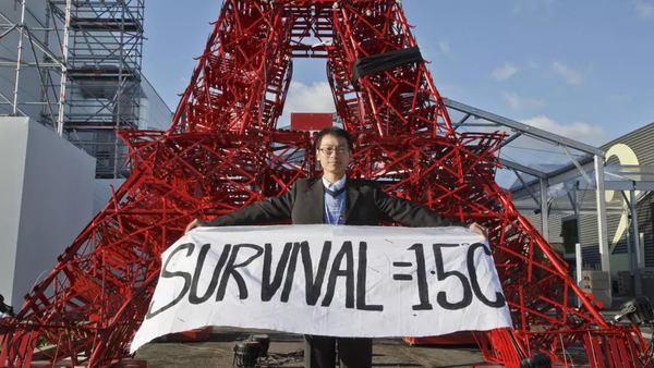 Учасник протесту тримає плакат із написом «Виживання = 1,5°C». Париж, Франція, г
