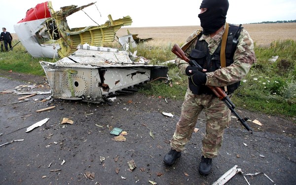 Фото:  Обломки боинга и сепаратист. Июль 2014. Фото: Reuters