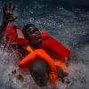 Спасатели достают из воды беженцев, переплывавших Средиземное море. Фото: Mathieu Willcocks