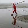 Индус в костюме Санта-Клауса после уборки  берега реки Ганг в Аллахабаде 23 декабря 2014 года Фото: Reuters / Jitendra  