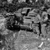 Американские войска 3-й танковой дивизии изучают немецкую самоходно-артиллерийскую установку «Штурмгешютц III» с мертвым немцем