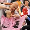 Южнокорейскому мальчику бреют голову, ребенка готовят к буддийскому монашеству.Фото:AFP