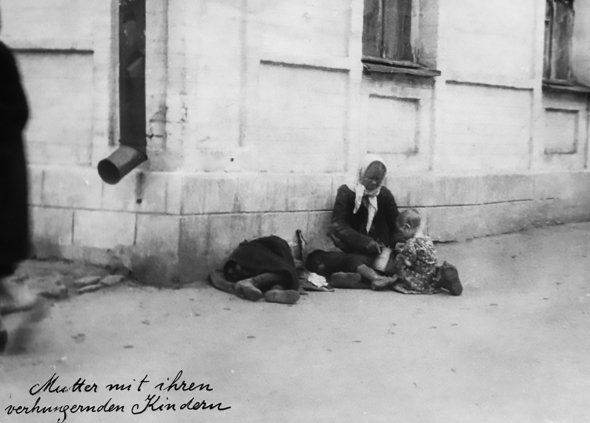 Фото:  Жінка зі своїми голодними дітьми сидить на вулиці в Харкові, 1933 рік