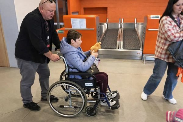 Фото:  Волонтер Каєтан Ян Врублевський допомагає українській переселенці з інвал