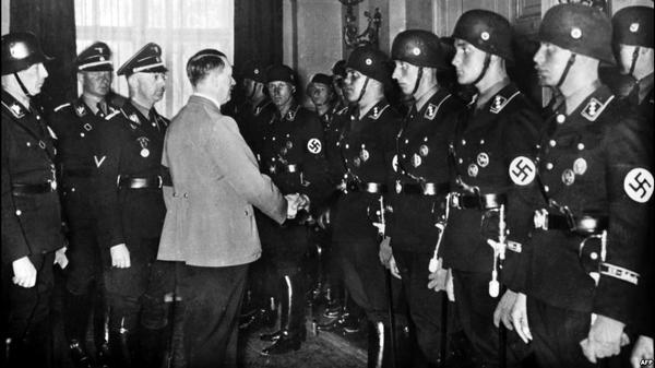 Фото:  Канцлер Германии Адольф Гитлер (в гражданском) пожимает руки молодым бойц