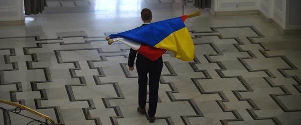 Працівник Канцелярії Сейму несе прапори України та Польщі. Фото: Адам Хелстовськ