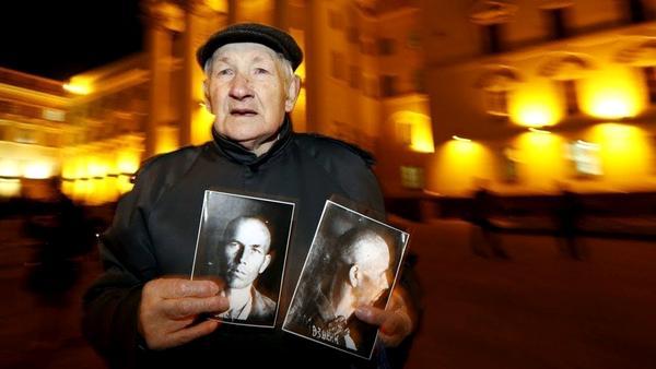 Фото:  Житель Минска с портретом замученного чекистами отца возле здания КГБ в М